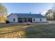 Back exterior of the home with a covered back porch and manicured backyard at 5761 Dixie Hwy, Rutledge, GA 30663