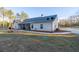 Exterior side view of the home with a spacious yard and concrete driveway at 5761 Dixie Hwy, Rutledge, GA 30663