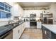 Kitchen area with stainless steel appliances, black countertops, and white cabinetry at 5761 Dixie Hwy, Rutledge, GA 30663