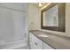 Bathroom with tub/shower, decorative mirror, sink with cabinets, and tile flooring at 7740 Sagebrush Dr, Atlanta, GA 30350