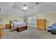 Large primary bedroom with neutral walls, tray ceiling, crown molding, sitting area, and three windows at 7740 Sagebrush Dr, Atlanta, GA 30350