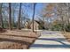 Long driveway leading to a two-story brick home with mature trees in a wooded setting at 7740 Sagebrush Dr, Atlanta, GA 30350