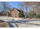 Side exterior view of a two-story brick home surrounded by lush greenery at 7740 Sagebrush Dr, Atlanta, GA 30350