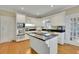 Bright kitchen boasts white cabinets, stainless steel appliances, and a center island with black countertop at 7740 Sagebrush Dr, Atlanta, GA 30350