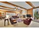 Cozy living room with exposed wood ceiling beams, fireplace, and comfortable seating at 7740 Sagebrush Dr, Atlanta, GA 30350