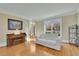 Bright living room featuring hardwood floors, a white sofa, and a piano at 7740 Sagebrush Dr, Atlanta, GA 30350