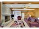 Cozy living room with brick fireplace, wood paneling, built-in bookshelves, and comfortable seating at 7740 Sagebrush Dr, Atlanta, GA 30350