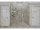 Beautifully tiled frameless shower with multiple shower heads is nestled between two doors in the bathroom at 7740 Sagebrush Dr, Atlanta, GA 30350