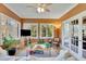 A sunroom with many windows has tile flooring, double doors, and a comfortable sitting area at 7740 Sagebrush Dr, Atlanta, GA 30350