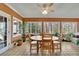 Bright sunroom with tiled floor and round wooden table with chairs, surrounded by many windows at 7740 Sagebrush Dr, Atlanta, GA 30350