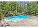 Backyard swimming pool surrounded by a concrete deck, mature trees and lush landscaping at 7740 Sagebrush Dr, Atlanta, GA 30350