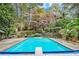 Backyard swimming pool with diving board, deck, mature trees and lush landscaping at 7740 Sagebrush Dr, Atlanta, GA 30350
