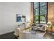 Inviting living room features exposed brick, tall windows, and comfortable seating with contemporary decor at 170 Boulevard Se # E127, Atlanta, GA 30312