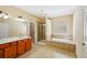 Bathroom with dual sinks, large soaking tub, and tiled walk-in shower at 189 Privet Cir, Suwanee, GA 30024