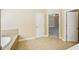 Bathroom with soaking tub and tan tile flooring and trim at 189 Privet Cir, Suwanee, GA 30024