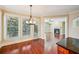 Bright dining area with hardwood floors, modern lighting, and views to the living room and outdoor deck at 189 Privet Cir, Suwanee, GA 30024