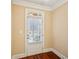 Interior shot of a white paneled door with window and blinds, contrasting with rich hardwood flooring at 189 Privet Cir, Suwanee, GA 30024