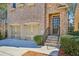 Close-up of a brick home's entrance, highlighting the attached garage and stone steps at 189 Privet Cir, Suwanee, GA 30024