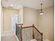 Hallway with neutral walls, carpet flooring, wooden railings, and pendant lighting at 189 Privet Cir, Suwanee, GA 30024