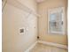 A well lit laundry room features a metal shelf and neutral tile flooring at 189 Privet Cir, Suwanee, GA 30024