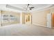 Large primary bedroom with tray ceilings, neutral walls and carpet, with a view to the en-suite bathroom at 189 Privet Cir, Suwanee, GA 30024