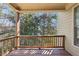 Exterior view of covered porch with wooden railing, siding, and peaceful wooded surroundings at 189 Privet Cir, Suwanee, GA 30024