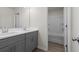 Bathroom vanity featuring gray cabinetry, white countertop, dual sinks, and view of a tub at 2955 Jefferson St, Austell, GA 30106