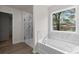 Bright bathroom featuring a soaking tub, a separate shower, and a window with a neighborhood view at 2955 Jefferson St, Austell, GA 30106