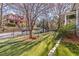 Expansive backyard features lush artificial grass, mature trees, and a bench, creating a serene outdoor oasis at 1069 Colquitt Ne Ave, Atlanta, GA 30307