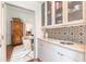 Convenient butler's pantry features marble counters, patterned tile backsplash, and glass-front cabinets at 1069 Colquitt Ne Ave, Atlanta, GA 30307