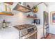 Close-up of a stainless steel stove and oven, complemented by white subway tile and open shelving at 1069 Colquitt Ne Ave, Atlanta, GA 30307
