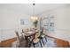 Cozy dining room featuring a wood table with seating for six, a modern chandelier, and hardwood floors at 345 Crown Vetch Ln, Alpharetta, GA 30005