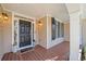 Welcoming front porch features a dark door, warm lighting, and a stylish 