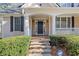 Inviting front porch with stone steps, black door, white columns, and neat landscaping at 345 Crown Vetch Ln, Alpharetta, GA 30005
