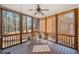 Enclosed porch with wooden flooring, decorative shades, and views of the wooded area at 345 Crown Vetch Ln, Alpharetta, GA 30005