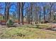 Backyard features a wood fence, mature trees, and small shed in a lush green and wooded yard at 4663 Hairston Crossing Pl, Stone Mountain, GA 30083