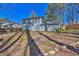 Backyard showing a gray two-story house, surrounded by a wooden fence, and mature trees at 4663 Hairston Crossing Pl, Stone Mountain, GA 30083