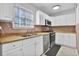 Efficient kitchen equipped with white cabinets, stainless steel appliances, and durable countertops at 4663 Hairston Crossing Pl, Stone Mountain, GA 30083