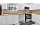 Updated kitchen with stainless steel appliances, including a gas range, complemented by white cabinetry and bright lighting at 4663 Hairston Crossing Pl, Stone Mountain, GA 30083