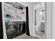 Laundry Room with modern washer and dryer, white shelving, and adjacent bathroom with tile at 4663 Hairston Crossing Pl, Stone Mountain, GA 30083