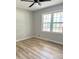 Simple bedroom featuring wood floors, and a large window with a view of the backyard at 112 Village Ct, Woodstock, GA 30188