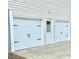 Spacious three-car garage with white doors and traditional black hardware at 112 Village Ct, Woodstock, GA 30188