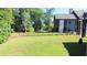 A spacious backyard offers a large grassy area surrounded by mature trees and an iron fence at 584 Cherokee Ne St, Marietta, GA 30060