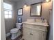 Charming powder room with a decorative vanity, mirror, sconces, and a window at 584 Cherokee Ne St, Marietta, GA 30060