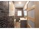 Modern bathroom featuring brick accent wall, tub, vanity, and glass door at 584 Cherokee Ne St, Marietta, GA 30060