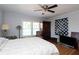 This bedroom features wood floors, a ceiling fan, large windows, and a dark wood armoire at 584 Cherokee Ne St, Marietta, GA 30060