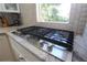 Close up on stainless steel cooktop with granite counters and tiled backsplash at 584 Cherokee Ne St, Marietta, GA 30060