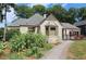 Quaint house with gray roof, stone walkway, beautiful landscaping, and an American flag, oozing curb appeal at 584 Cherokee Ne St, Marietta, GA 30060