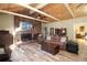 Open-concept living room with a brick fireplace, wood floors and vaulted ceiling with exposed beams at 584 Cherokee Ne St, Marietta, GA 30060