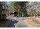 This driveway leads to a home with multiple wooden outbuildings, lush trees and a small gazebo at 231 Holly Springs Ne Rd, White, GA 30184